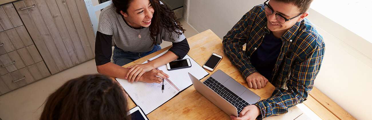 Friends-work-around-a-tabletop-with-multiple-devices