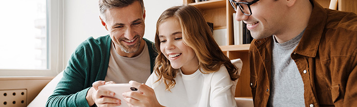 Dads and daughter using mobile device together