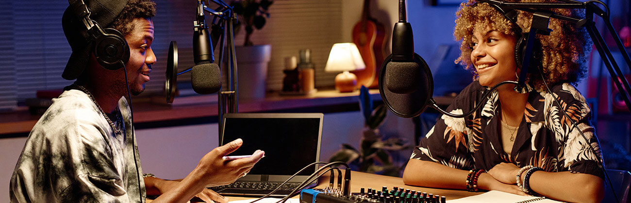 Two young people livestream with Gig speed in a well-equipped home studio